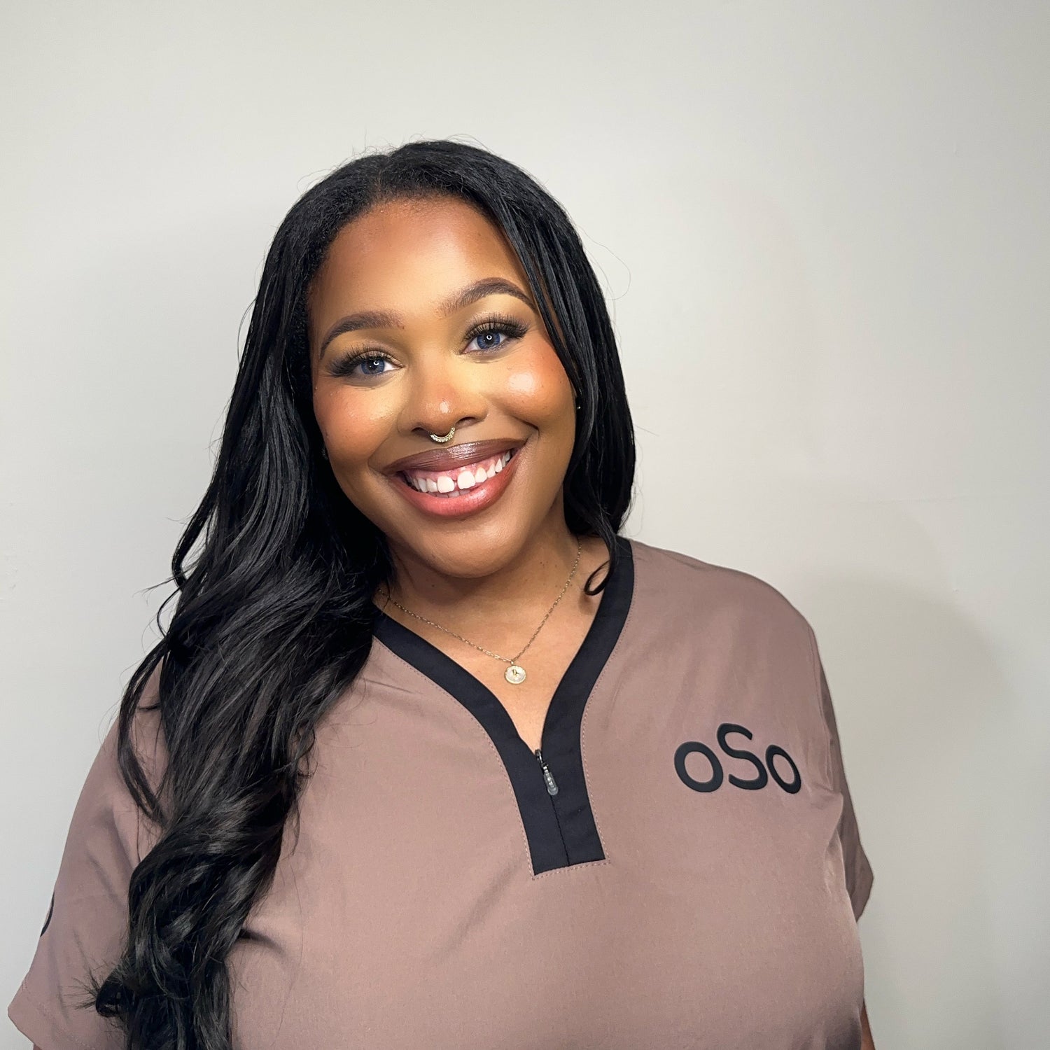Woman wearing a brown shirt with 'oSo' logo 